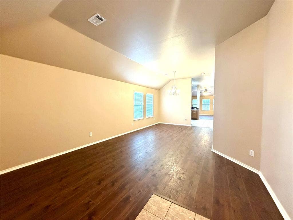 9016 Warren Drive, McKinney, TX 75071 This spacious, light-filled living and dining area features a desirable open-concept floor plan that allows for seamless flow between rooms. The space is finished with durable, high-quality wood-look solid surface flooring throughout, combining the warm, aesthetic appeal of natural hardwood with the low-maintenance benefits of modern materials, perfect for both everyday comfort and sophisticated entertaining.