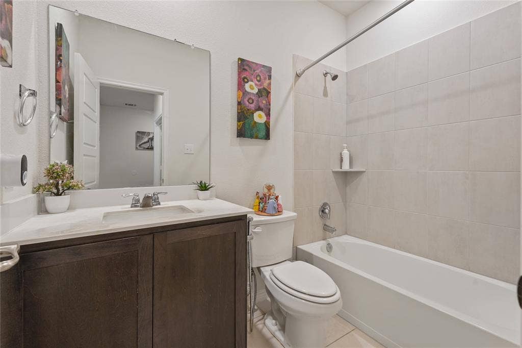 Integrated bathtub and shower with subway tile surround, a built-in shower shelf, and a chrome fixture