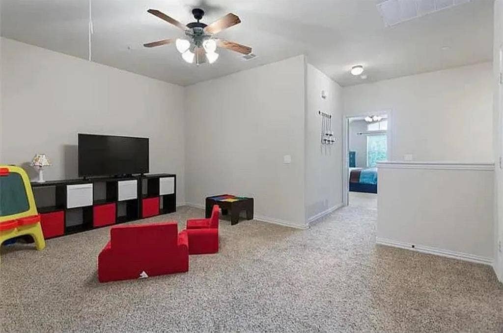 Recreation room featuring ceiling fan and carpet flooring