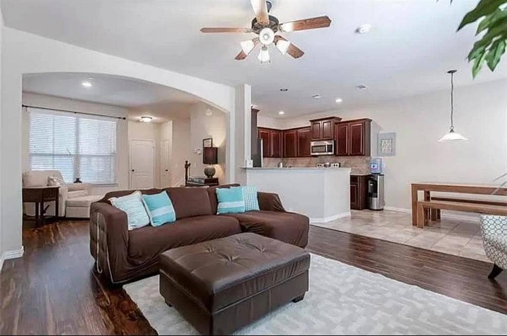 Living room with ceiling fan and light hardwood / wood-style flooring