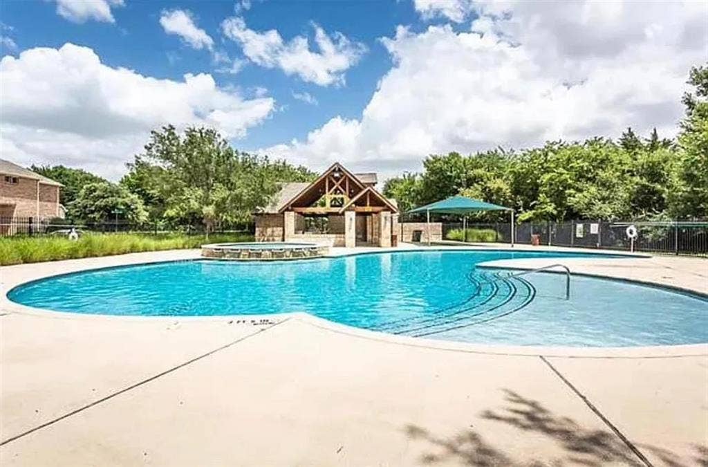 View of pool with a community hot tub and a patio