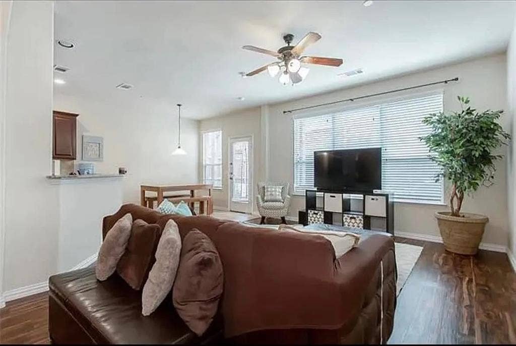 Living room with ceiling fan and dark hardwood / wood-style flooring