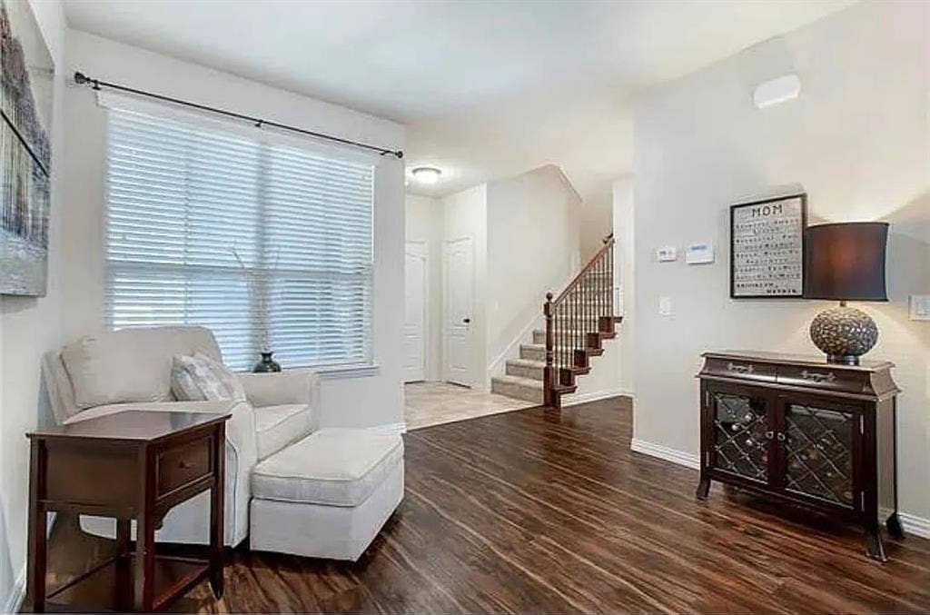 Sitting room with a wealth of natural light and dark hardwood / wood-style flooring