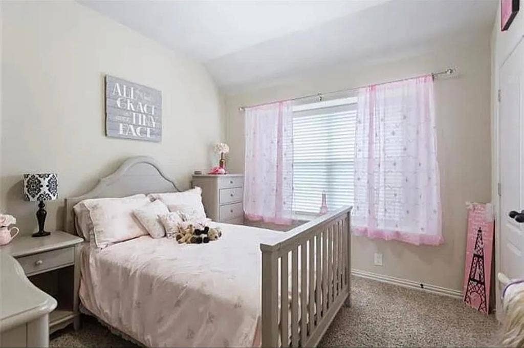 Carpeted bedroom featuring vaulted ceiling
