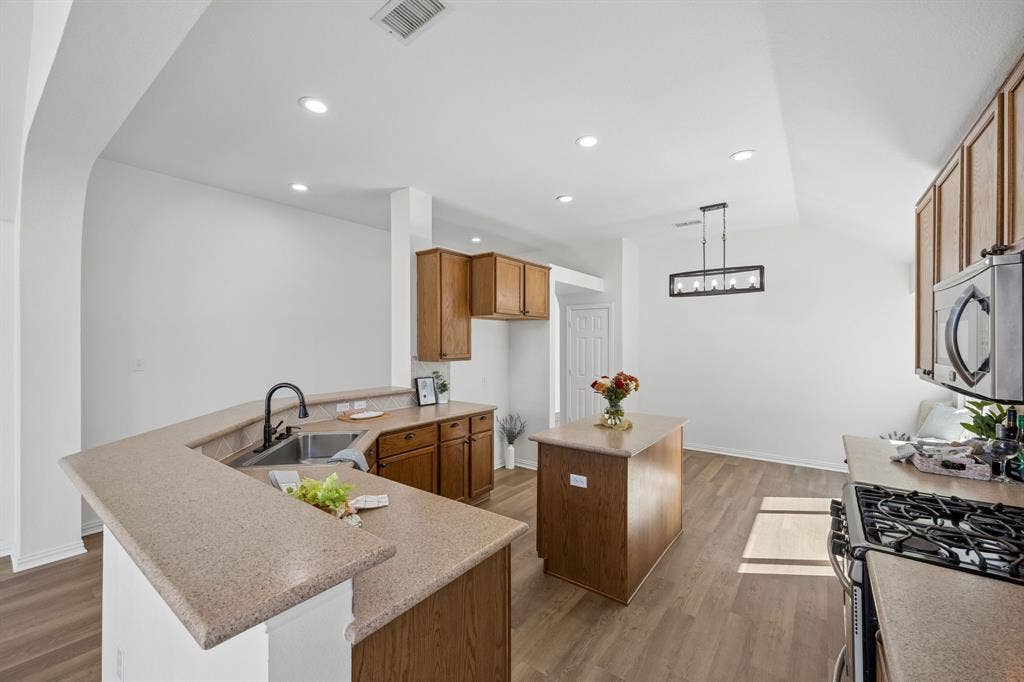 This view of the Gourmet Kitchen shows beauty and the functionality with the abundant cabinetry, generous counter tops and inviting open concept feel!  This picture shows the sweet plant ledge, too!