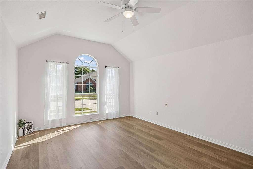 And Now... welcome to the Primary Bedroom retreat! Vaulted ceiling, arched windows and beautiful wood look flooring make this room special!