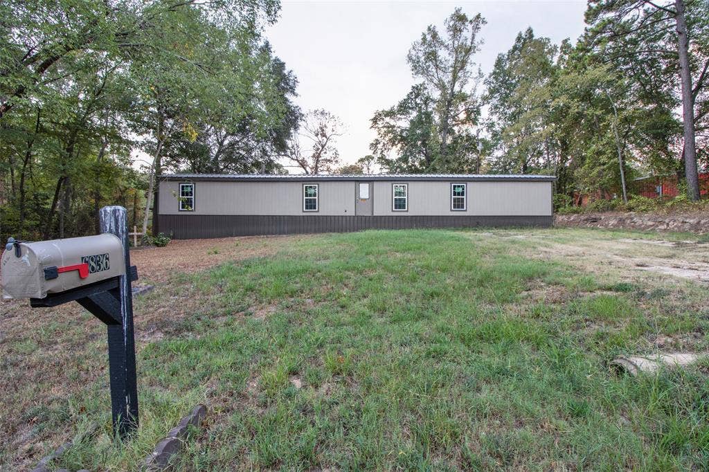 Single-story manufactured residence with multiple windows and a neutral-toned exterior