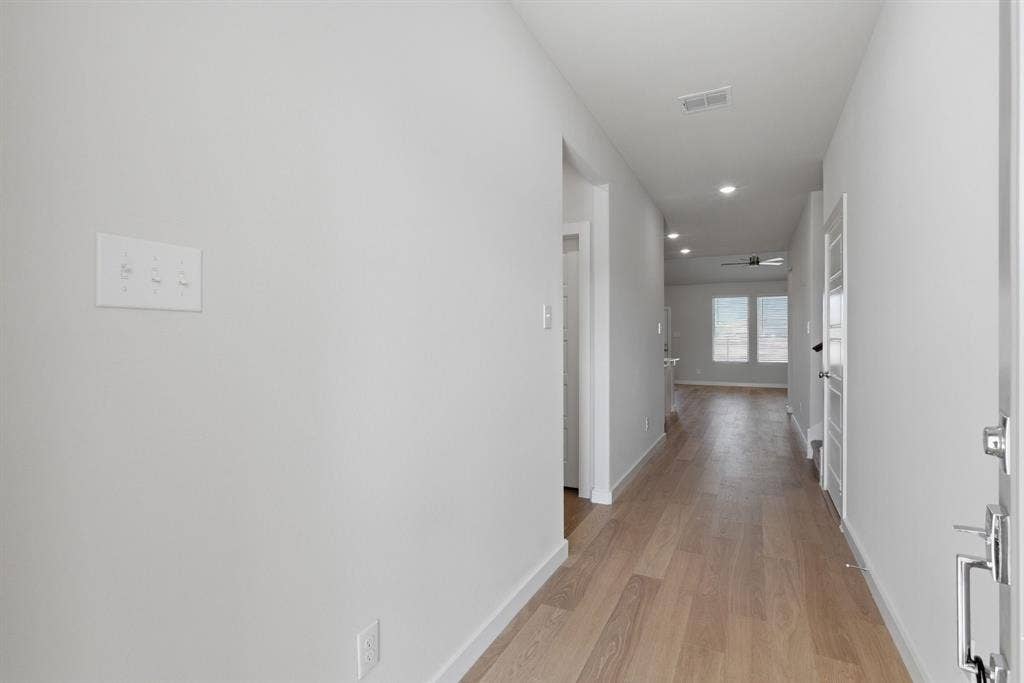 637 Sierra Ridge, Lavon, TX 75166 Recessed lighting illuminates wood-finish flooring throughout the hallway