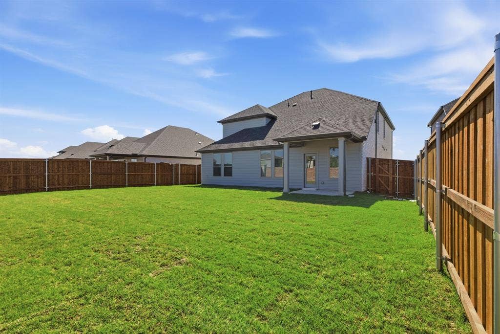 637 Sierra Ridge, Lavon, TX 75166 Expansive yard with wood fencing, a covered patio, and a grass lawn