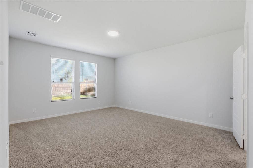 637 Sierra Ridge, Lavon, TX 75166 Neutral carpeted flooring, light gray wall paint, two windows with blinds, and a ceiling-mounted light fixture