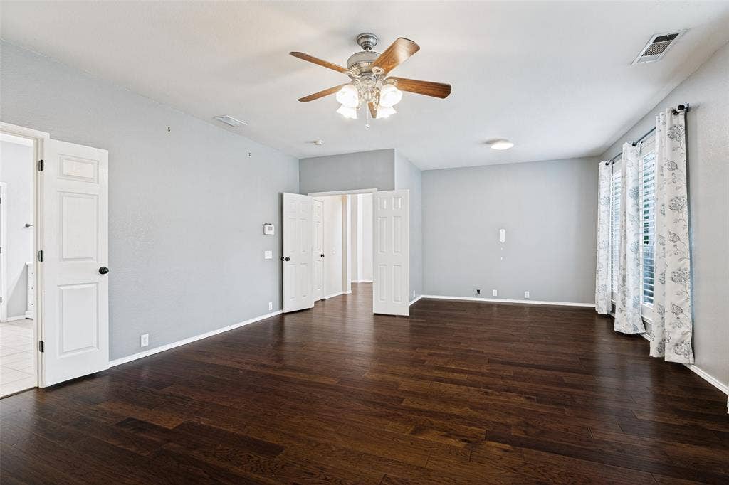 Primary bedroom with engineered wood flooring, plantation shutters, and flex space