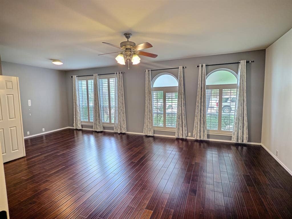Primary bedroom with engineered wood flooring, plantation shutters, and flex space