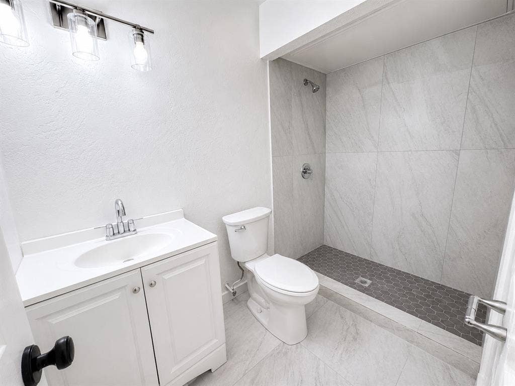 542 Hanover Drive, Allen, TX 75002 Bathroom featuring a white vanity with integrated sink, chrome faucet, and three-light vanity bar