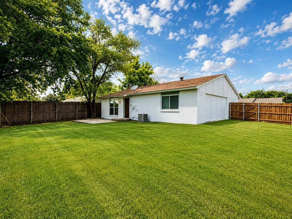542 Hanover Drive, Allen, TX 75002 Spacious backyard featuring a large grass lawn, privacy fencing, and mature trees