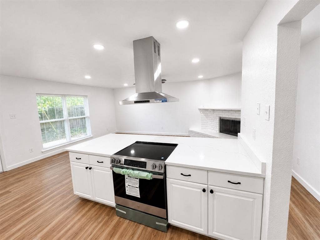 542 Hanover Drive, Allen, TX 75002 Kitchen island featuring a built-in range, white shaker-style cabinetry, and white countertops