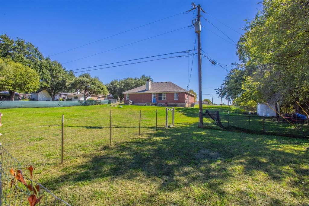 Expansive green lawn with a brick exterior property and mature trees