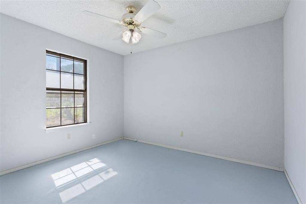 204 Ausborn Street, Eddy, TX 76524 Smooth wall finishes, grid-pattern window, ceiling fan with integrated lighting, and light-toned flooring