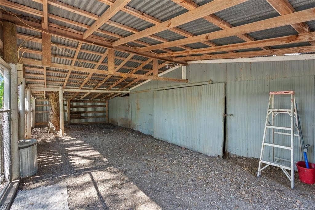 204 Ausborn Street, Eddy, TX 76524 Open-air structure with exposed wood beam ceiling, corrugated metal roofing, and gravel flooring