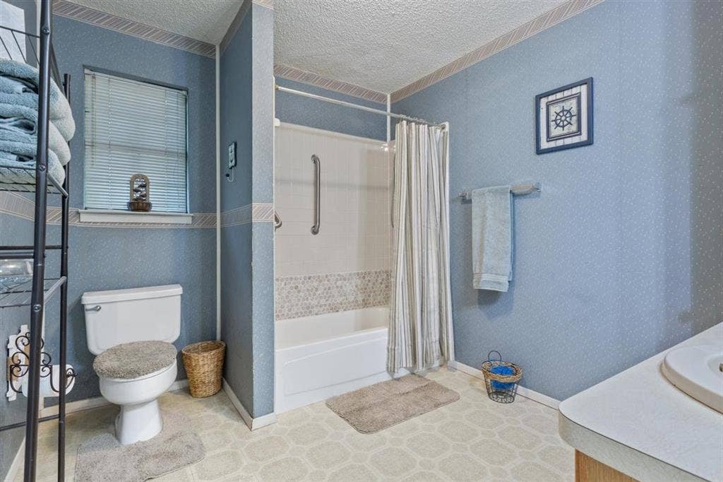 204 Ausborn Street, Eddy, TX 76524 Bathtub and shower combination with mosaic tile surround and grab bars