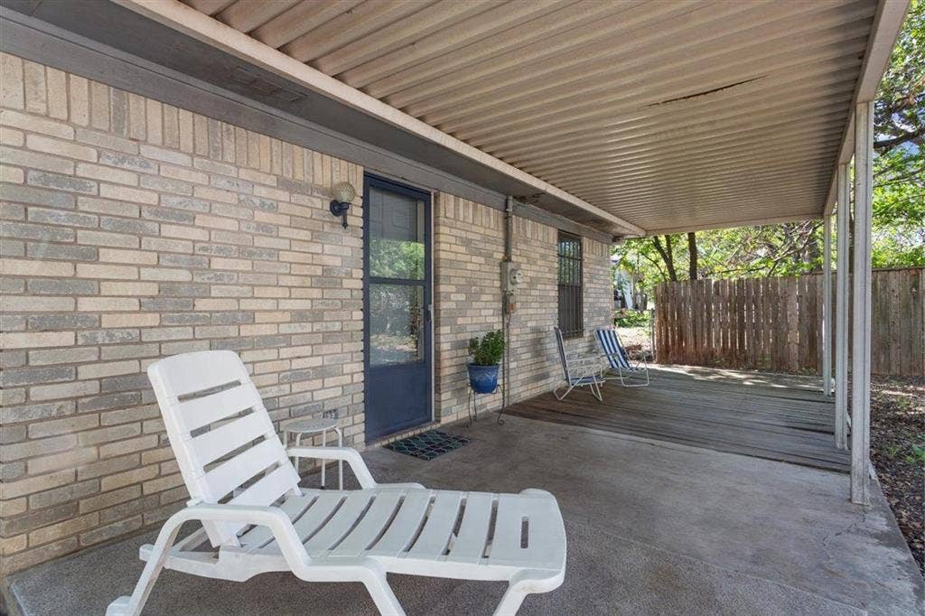 204 Ausborn Street, Eddy, TX 76524 Covered patio with a corrugated metal roof, brick exterior, and wood deck