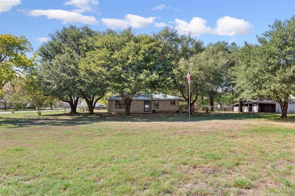 204 Ausborn Street, Eddy, TX 76524 Brick exterior with a composition roof, surrounded by mature trees