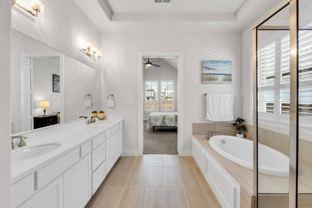 2971 Gaulding Drive, Prosper, TX 75078 Dual vanity with undermount sinks, built-in soaking tub, framed glass shower enclosure, and light-toned tile flooring