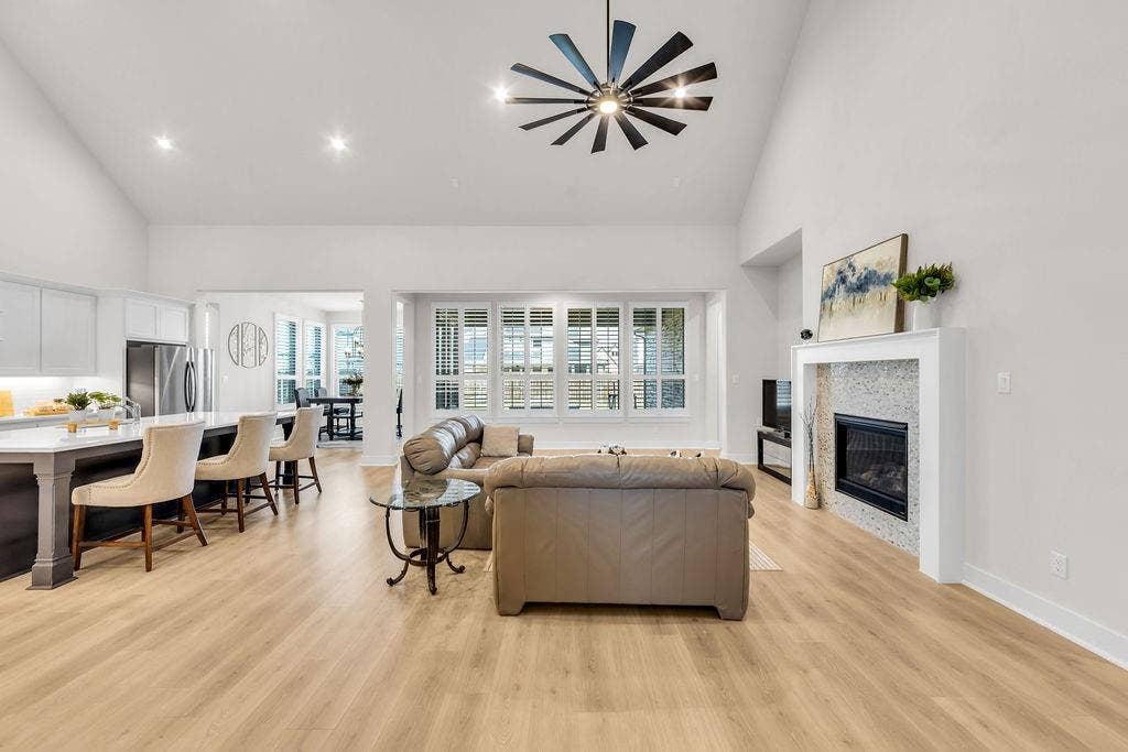 2971 Gaulding Drive, Prosper, TX 75078 Vaulted ceilings with a ceiling fan, recessed lighting, wood-finish flooring, and a fireplace with a decorative tile surround