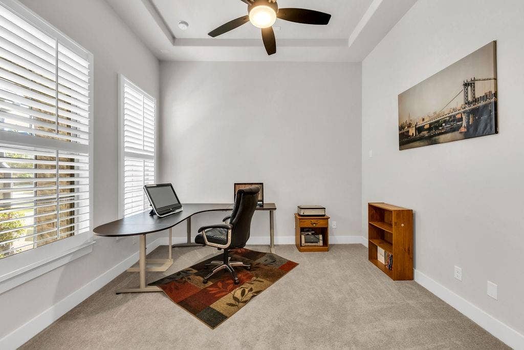 2971 Gaulding Drive, Prosper, TX 75078 Tray ceiling with a ceiling fan, two windows with plantation shutters, light gray wall paint, and light gray carpeting