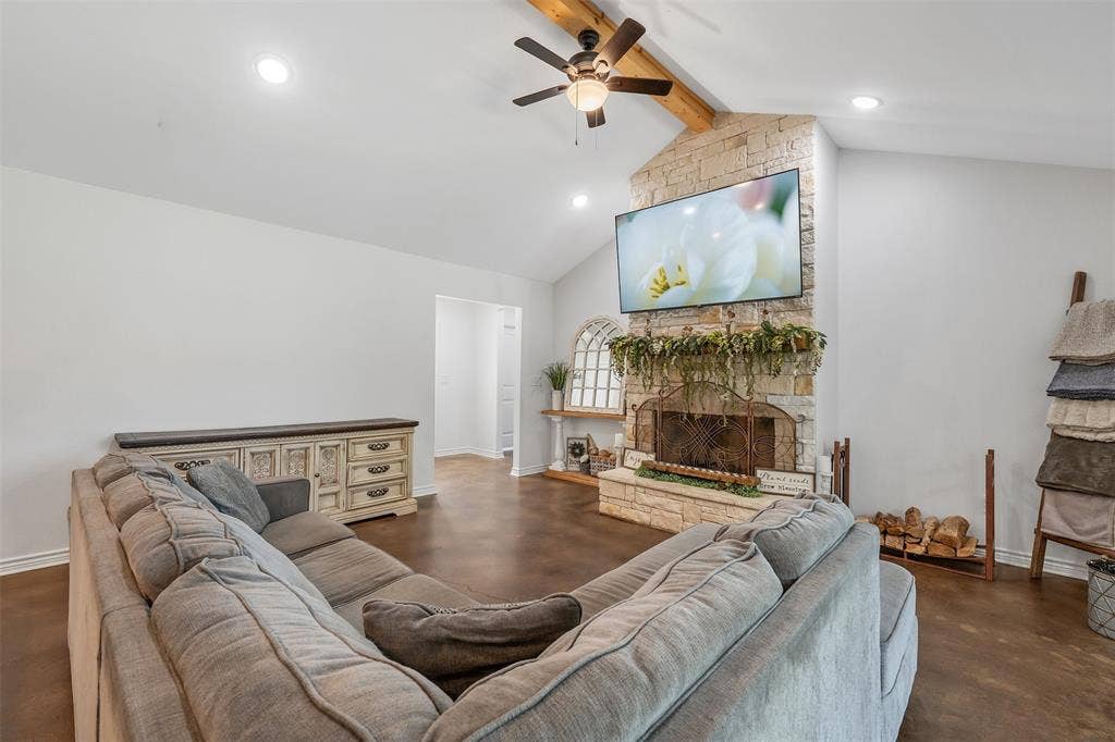 19731 County Road 4130, Lindale, TX 75771 Vaulted ceiling with exposed wood beam, stone fireplace with a hearth, integrated ceiling fan, recessed lighting, and wood-finish flooring