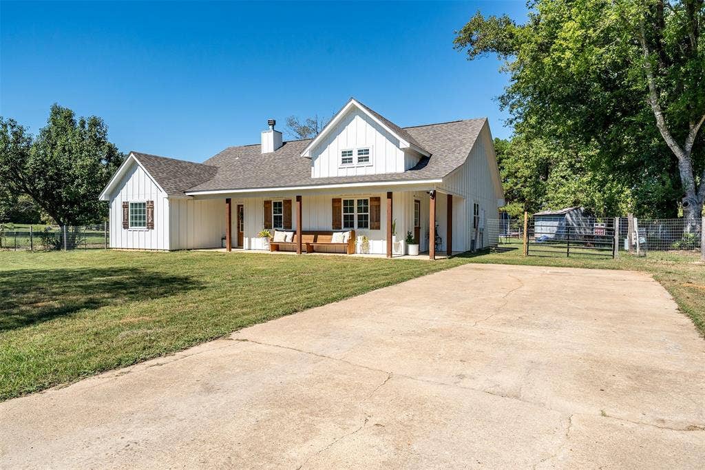 19731 County Road 4130, Lindale, TX 75771 White board and batten exterior with a covered porch, wood columns, and a gabled roof