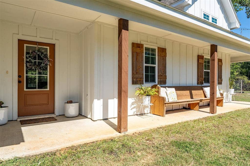 19731 County Road 4130, Lindale, TX 75771 Covered porch with concrete flooring, wood structural columns, and white board-and-batten siding