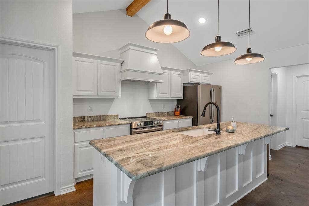 19731 County Road 4130, Lindale, TX 75771 Kitchen featuring a large island with an integrated sink, stone countertops, white cabinetry, and stainless steel appliances