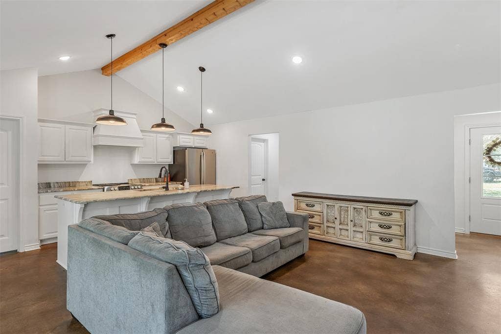 19731 County Road 4130, Lindale, TX 75771 Vaulted ceiling with exposed wood beam, kitchen with white cabinetry, stainless steel appliances, and island with pendant lighting, recessed lighting, and wood-finish flooring