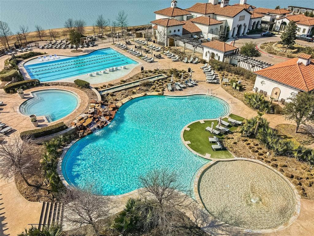 1416 White Squall Trail, Arlington, TX 76005 Resort-style amenities featuring multiple pools, a lap pool, a shallow water feature, and a clubhouse with traditional tile roofing