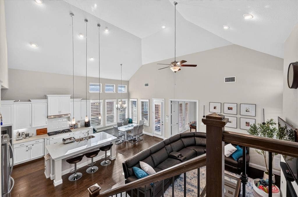 1416 White Squall Trail, Arlington, TX 76005 Vaulted ceilings, wood-finish flooring, white cabinetry, island with countertop seating, and recessed lighting