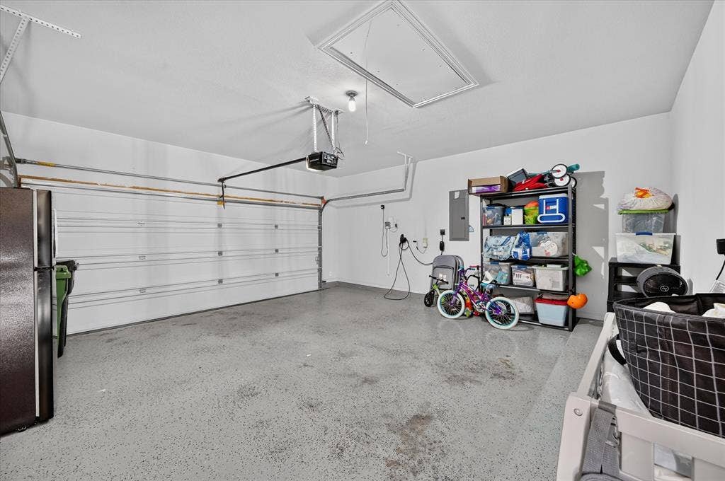 1416 White Squall Trail, Arlington, TX 76005 Attached garage featuring a white overhead door, finished walls, and an access panel