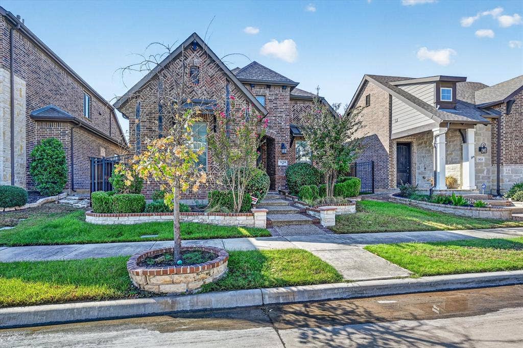 1416 White Squall Trail, Arlington, TX 76005 Brick facade with stone accents, gabled roofline, front porch with columns, landscaped yard, and concrete walkways