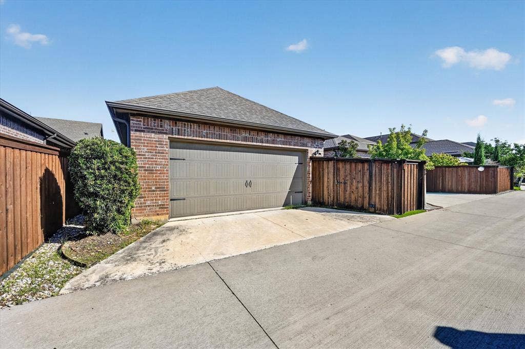 1416 White Squall Trail, Arlington, TX 76005 Brick exterior with an attached garage, wood privacy fencing, and a concrete driveway