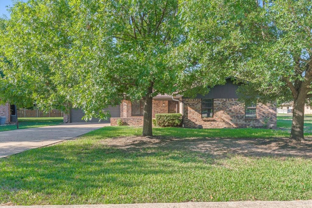 Mature trees accent this ranch style home