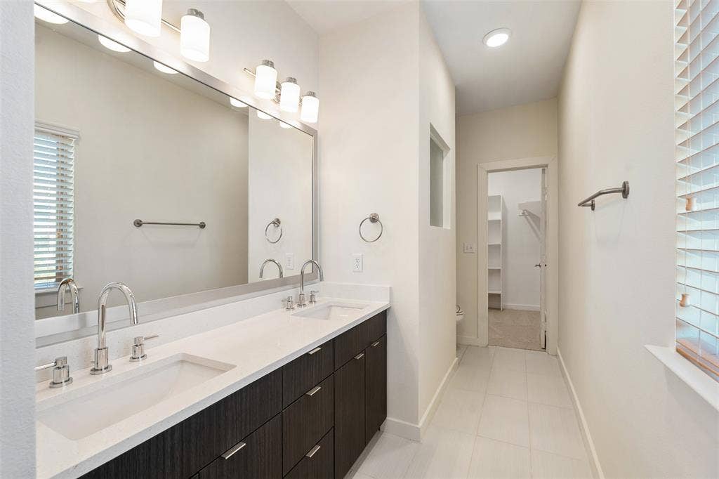 Dual vanity with integrated sinks, white countertop, and dark wood-finish cabinetry