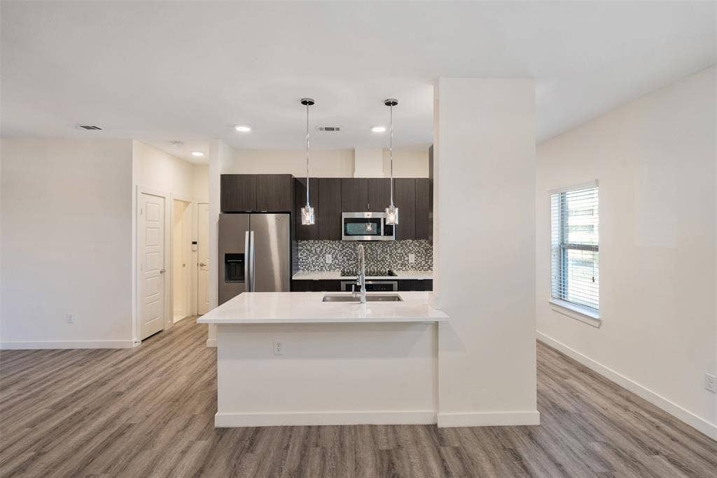 Kitchen island with a white countertop and pendant lighting