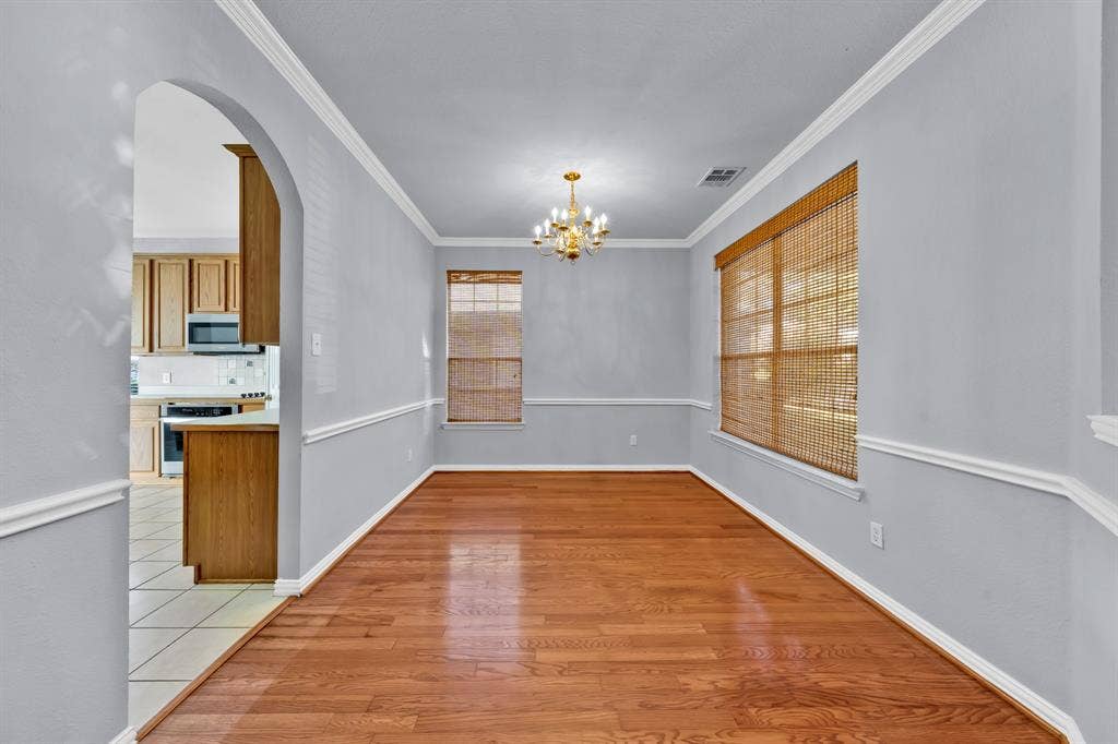 Hardwood-finish flooring, crown molding, chair rail molding, and a chandelier