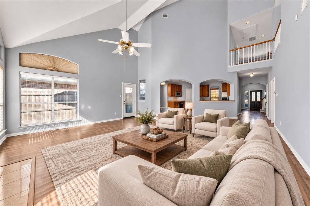Vaulted ceilings, wood-finish flooring, and arched doorways define this living space