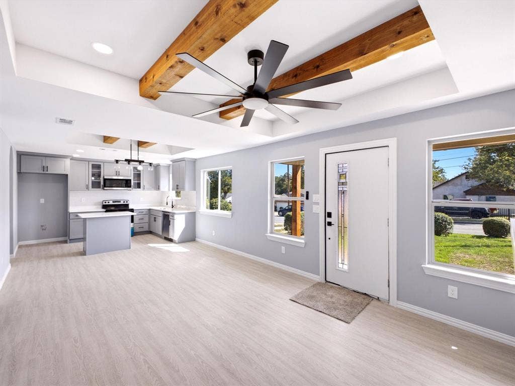 1727 Mentor Avenue, Dallas, TX 75216 Light wood-finish flooring throughout, tray ceiling with exposed wood beams, and a modern ceiling fan