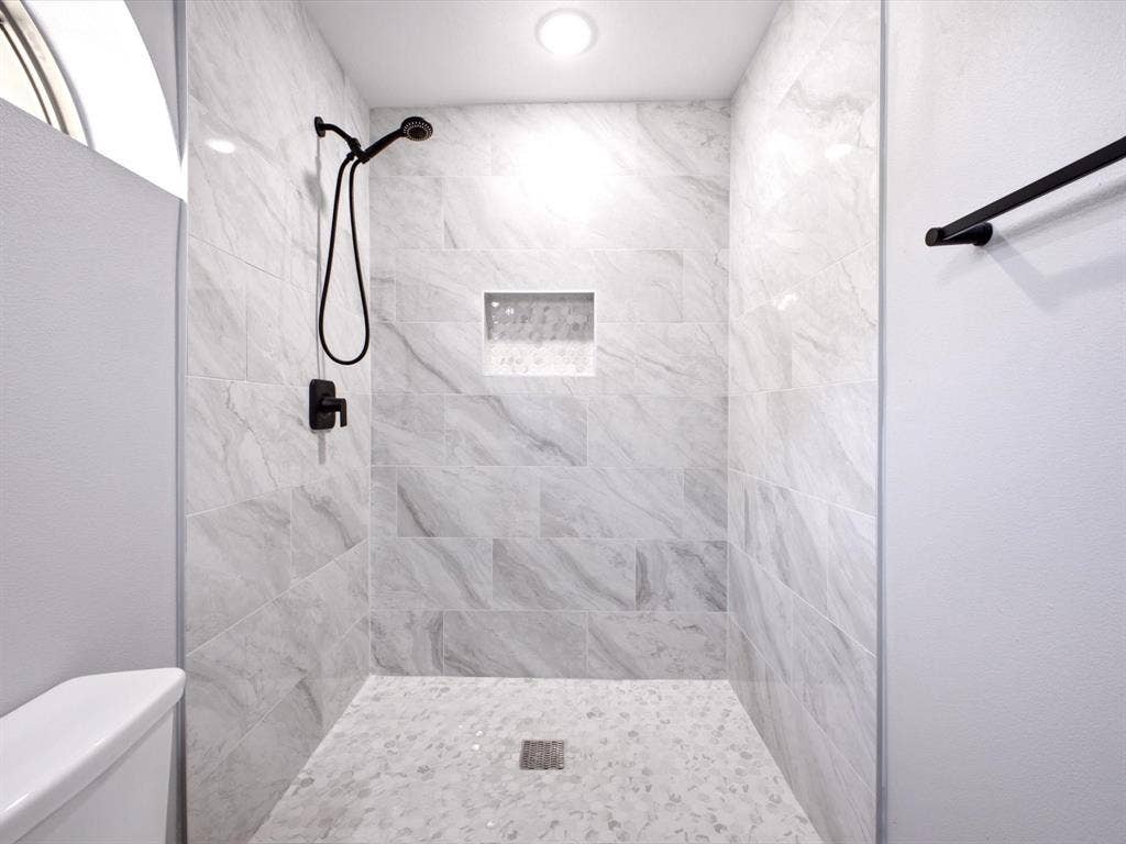 1727 Mentor Avenue, Dallas, TX 75216 Walk-in shower with large format wall tiles, a built-in shower niche, and a mosaic tile floor