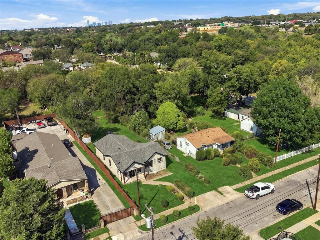 1727 Mentor Avenue, Dallas, TX 75216 Aerial perspective showcasing multiple properties, extensive tree coverage, and distant urban buildings