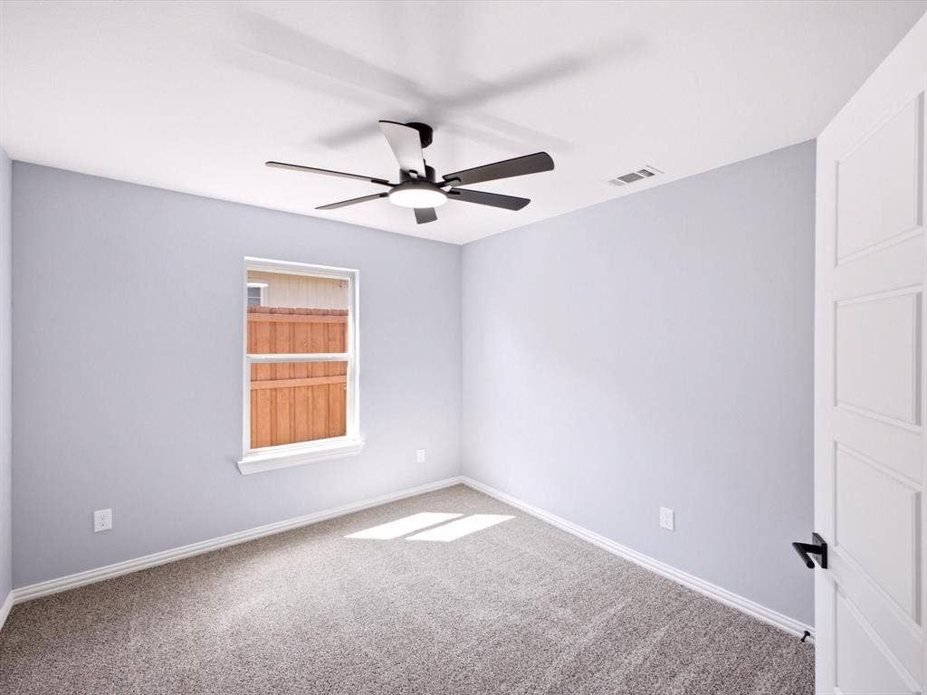1727 Mentor Avenue, Dallas, TX 75216 Gray wall paint, white trim, grey carpet, ceiling fan, and white panel door