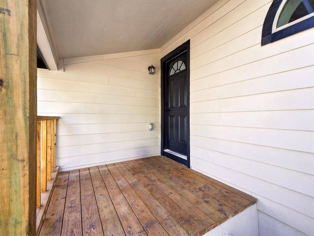 1727 Mentor Avenue, Dallas, TX 75216 Covered porch with wood plank flooring and a dark entry door