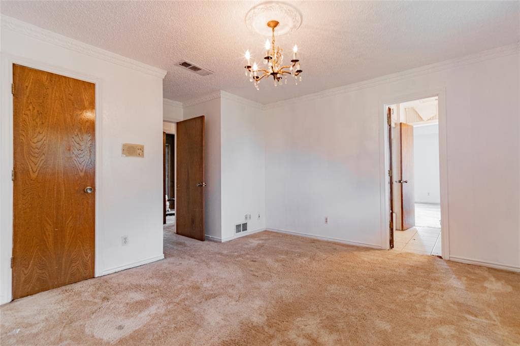 4320 Hickox Road, Rowlett, TX 75089 Crown molding, chandelier with ceiling medallion, and wood-panel doors