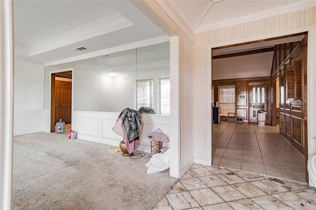 4320 Hickox Road, Rowlett, TX 75089 Tray ceiling, wainscoting, full wall mirror, wood paneling, and tile flooring